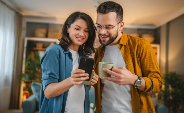 Ein Paar guckt gemeinsam auf ein Smartphone.